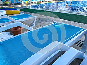 Sun loungers for relaxing and sunbathing with sun umbrellas near the pool for swimming and chilling in the hotel on vacation in a