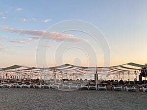 Sun loungers and sunshade with umbrellas on the beach on the sea on vacation in a tourist warm eastern tropical country southern