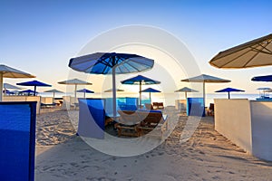 Sun loungers with umbrellas on the beach in Marsa Alam at sunrise, Egypt