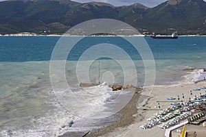 Sun loungers and umbrellas on the pebble beach in the resort of Kabardinka, Krasnodar region, Black sea.