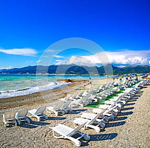 Sun loungers and umbrellas on the pebble beach in the resort of Kabardinka, Krasnodar region, Black sea.