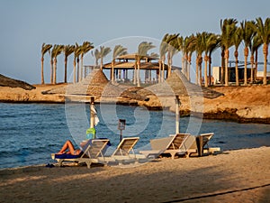 sun lounges at sunset with palm trees at the red sea