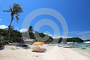 Sun lounges with umbrellas at Ilig Iligan Beach, Boracay Island, Philippines