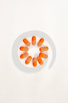 Sun made of orange pills on white background. childrens antipyretic concept. Close up top view.