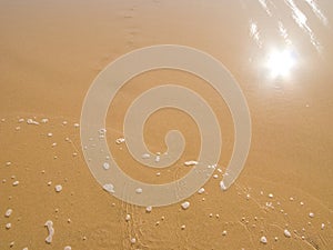 Sun mirrored in the wet sand beach