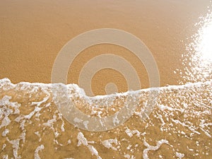 Sun mirrored in the wet sand beach