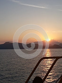 The sun and the moon side by side between the mountains at dusk