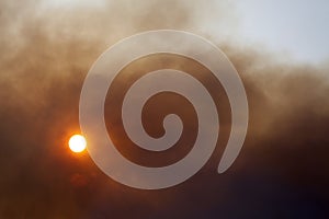 Sun obstructed by a cloud of smoke photo