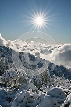 Sun over clouds on top of Salatin peak in Low Tatras during winter