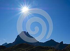 The sun over the Midi d`Ossau peak in the Pyrenees National Park.