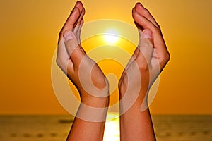 Sun over the sea in hands