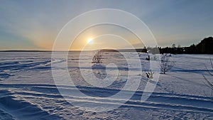 The sun over the snow-covered  lake in winter