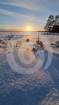 The sun over the snow-covered  lake in winter