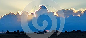 The sun is peaking through distant clouds, creating a silver lining