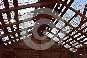 Sun Peeks Thru the Trees and Roof of old Barn