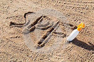 Sun protect factor. SPF word written on the sand and white bottle with suntan cream. Skin care concept background