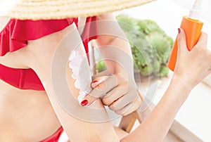 Sun protection concept. Hand of girl applying sun cream solar cream, sunscreen before tanning during summer on beach.