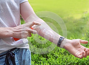 Sun protection. Hand of caucasian man applying sun cream & x28;sunscreen& x29; from a plastic container.