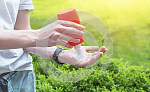 Sun protection. Hand of caucasian man applying sun cream sunscreen from a plastic container bottle.