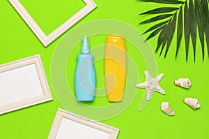 Sun protection Summer background vacation travel concept Yellow blue bottles of sunscreen cream tropical palm leaves shells