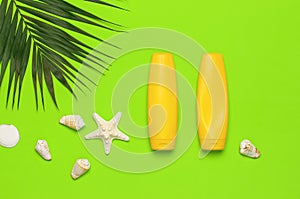 Sun protection. Summer background vacation travel concept Yellow bottles of sunscreen cream, tropical palm leaves