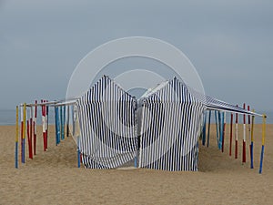 sun protection tents on the sand of the bathing beach in the town of NazarÃ© photo