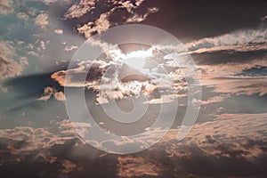 Sun ray through the clouds in straight lines against the background of the sky and rain clouds during sunset, picturesque sky