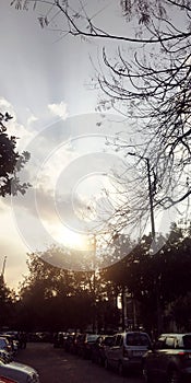 Sun rays behinds from clouds in the city