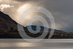 Sun rays breaking through clouds above lake Wanaka