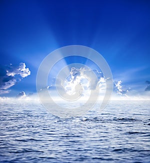 Sun rays with clouds on blue sky landscape.sunrise above clouds with reflection at ocean and very bright beams