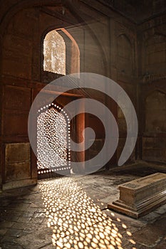 Sun rays create dramatic light and shadow inside of the humayun tomb memorial at winter foggy morning