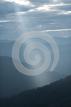 Sun rays filter through the clouds in hills of the valley illuminated by the sun's rays filtering through the clouds