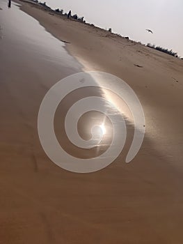 Sun rays reflection on beach sand and sea water