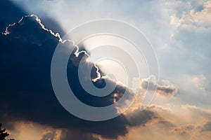 Sun rays shining from behind a big cloud