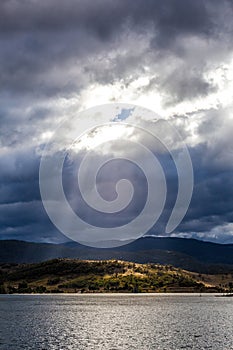 Sun Rays shining through clouds on the Hills of Lake Jindabyne,