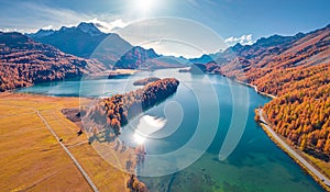 Sun reflected in the calm waterf of Sils lake.