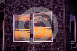 The sun reflects itself in the windows of beachfront homes in the pacifi coast; beautiful, dramatic skies and colors; golden light