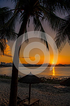The sun rises from the hills at Dadonghai beach, Sanya, China