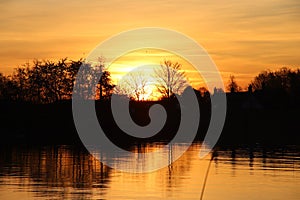 The sun rises over the water of the river Hollandsche IJssel near the dike at Park Hitland photo