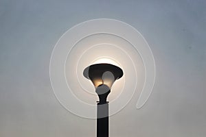 Sun rising behind the lamp.