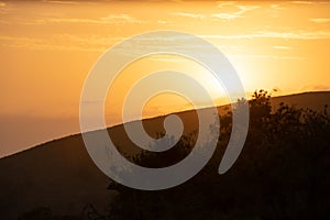 The sun rising at dawn over the hills of the Hluhluwe - imfolozi National Park in South africa