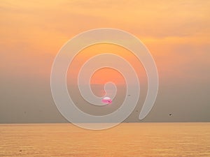 Sun is rising over horizon line with sea view and colorful sky