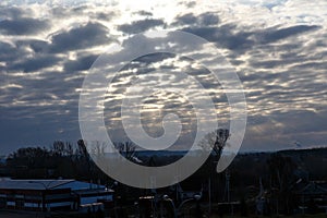 The sun`s rays through the clouds above the forest. Dark clouds at sunrise in Siberia. Siberian landscape