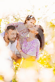 in the sun's rays. happy family in a blooming spring garden.