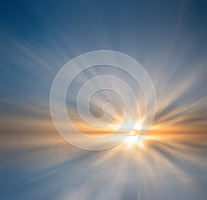 The sun`s rays make their way through the clouds at sunset, painting them against the backdrop of the ocean