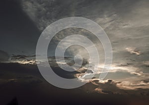 The sun`s rays passing through the clouds and shining form an interesting light pattern against the sky