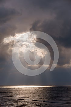 The sun's rays passing through the storm clouds over the sea