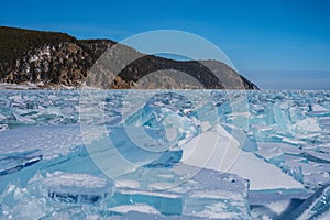 The sun\'s rays are refracted in crystal clear pieces of ice. winter landscape. A piece of ice and the sun on a winter lake.