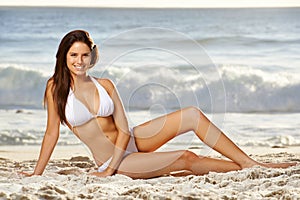 Sun, sea, sensuality...A gorgeous young woman posing in a white bikini on the beach.