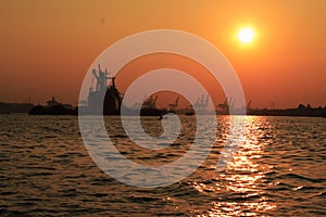 The sun set at the river , which have a ship on the background